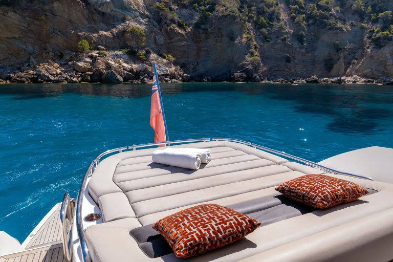 Large padded sunbed with cushions on the bow of a Sunseeker yacht