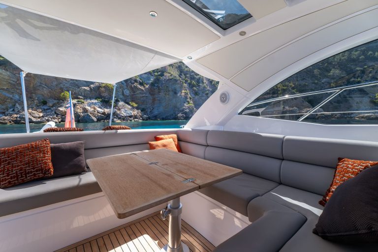 Shaded cockpit lounge with table and sofa seating on a Sunseeker yacht