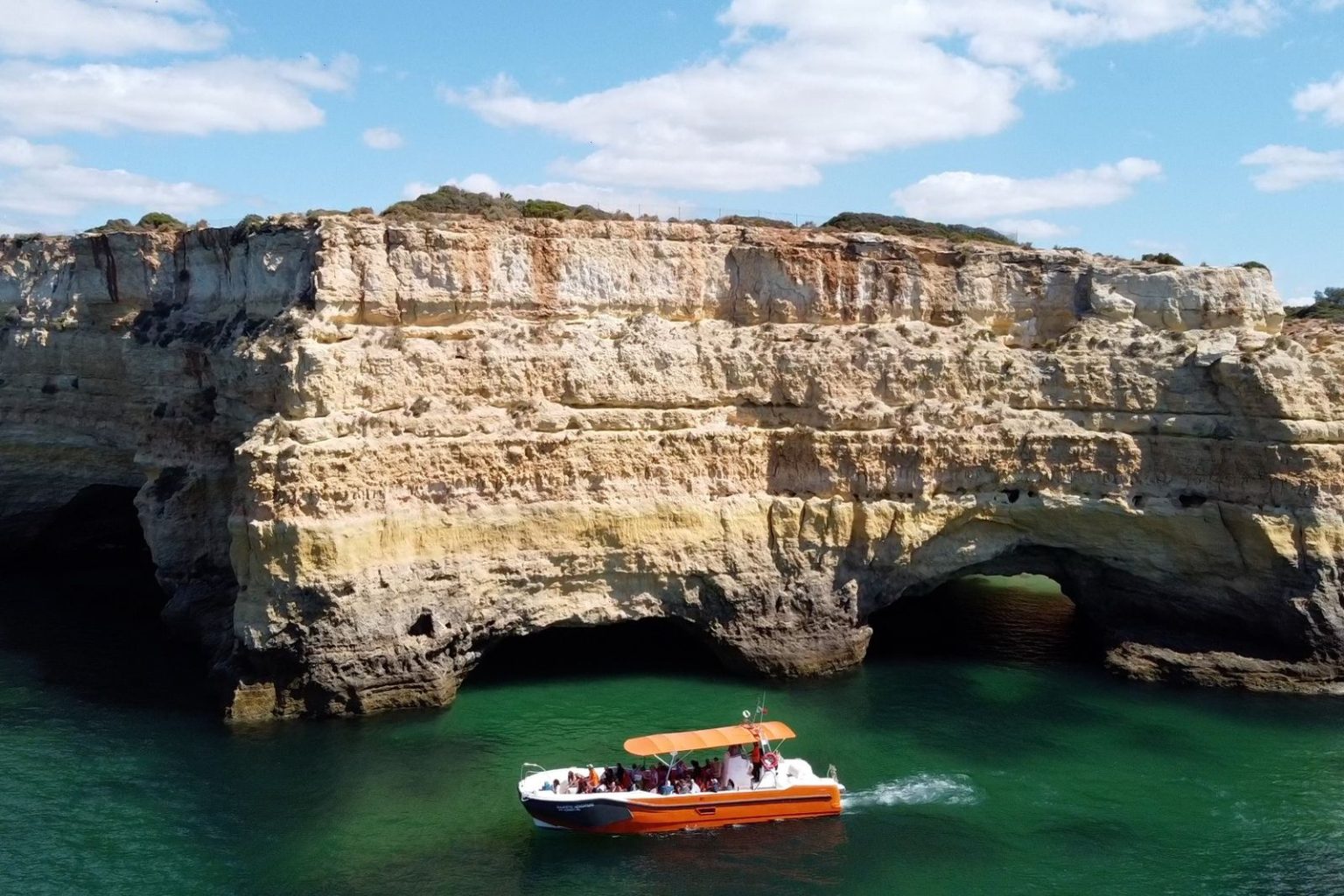 Boat beside the cliffs and caves near Benagil