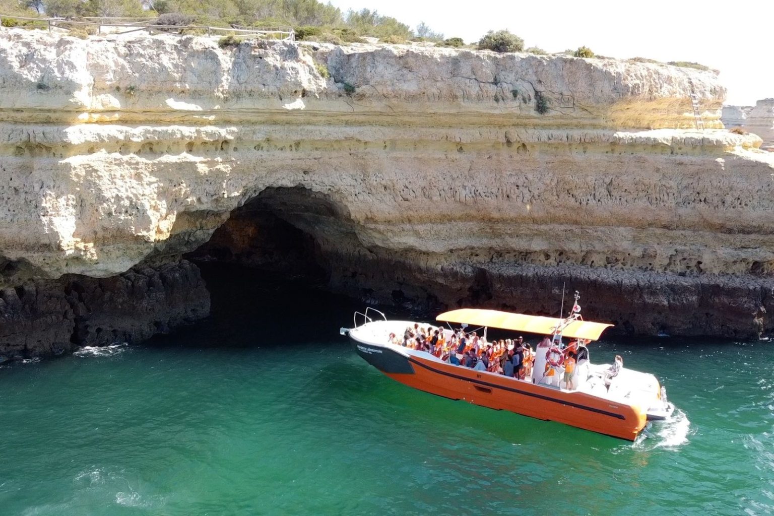 Boat at the entrance of a sea cave on the Algarve coast