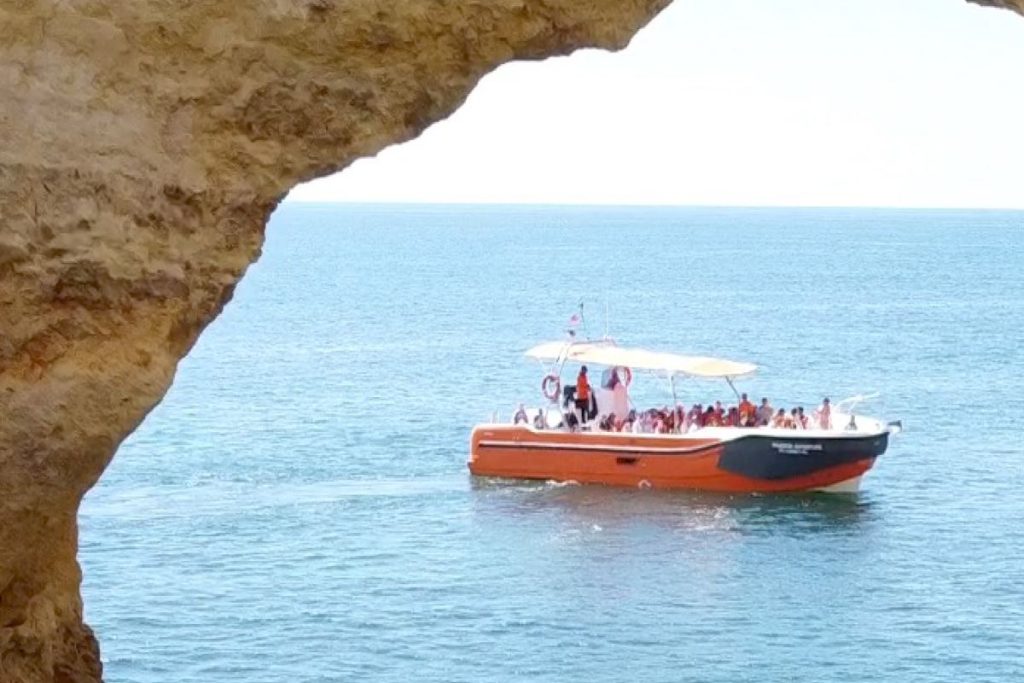 Boat beside a tall rock stack near Benagil