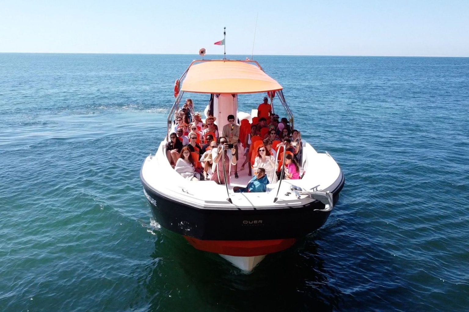 Boat full of guests on the blue sea