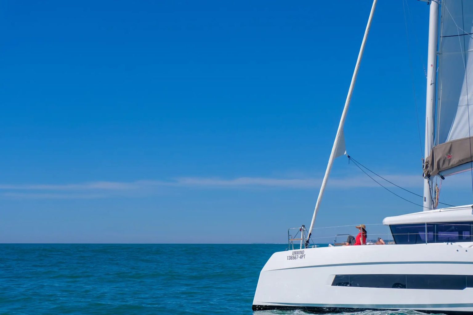 Guest relaxing on the deck of a private sailing catamaran in the Algarve