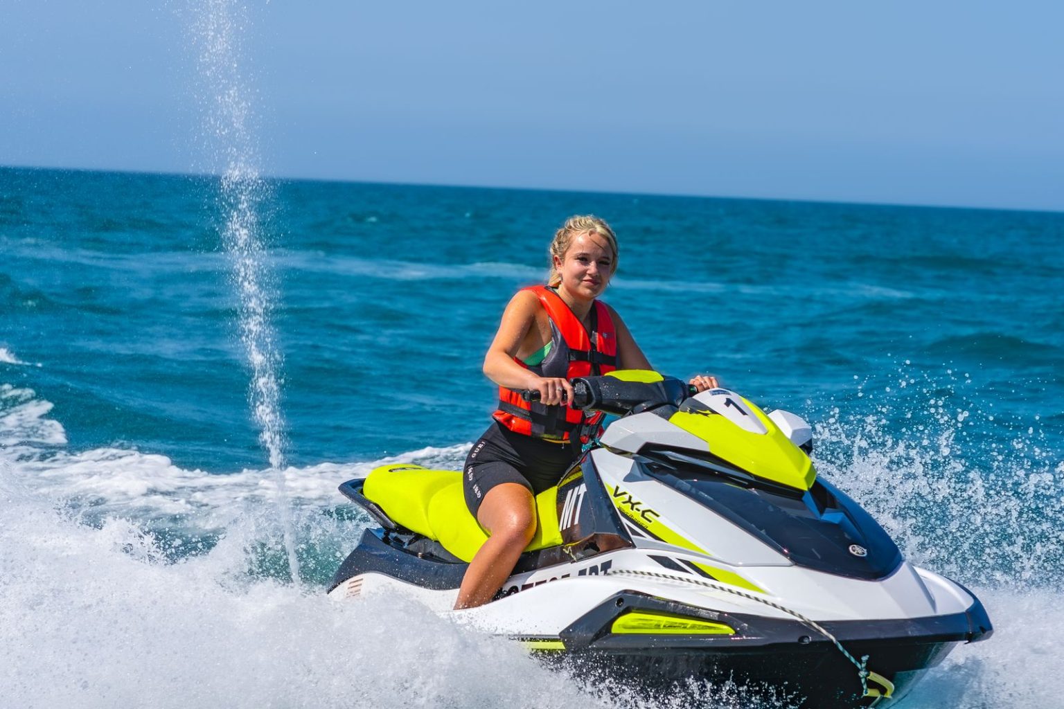 Smiling woman riding a jet ski for the first time