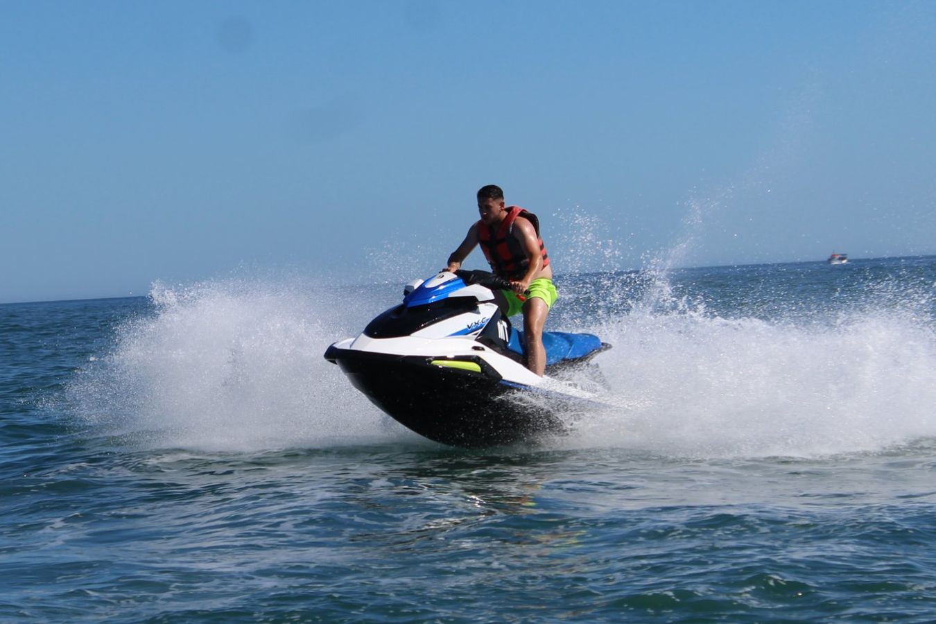 Close-up of a rider on a jet ski at speed with spray