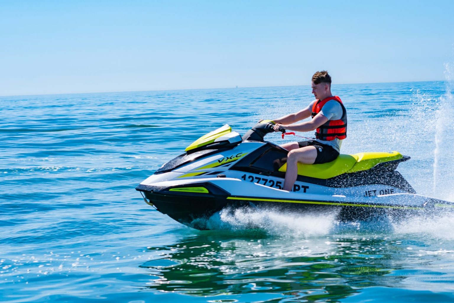 Rider on a green and white jet ski on the open sea