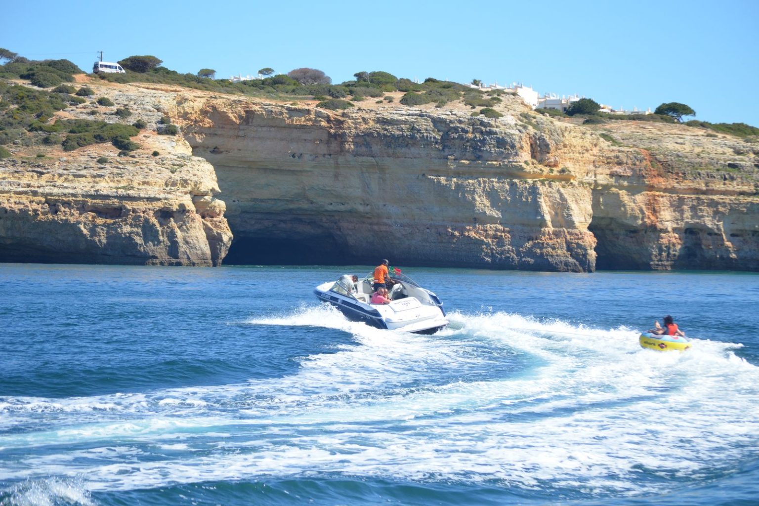 Jet skis riding past the golden Algarve cliffs