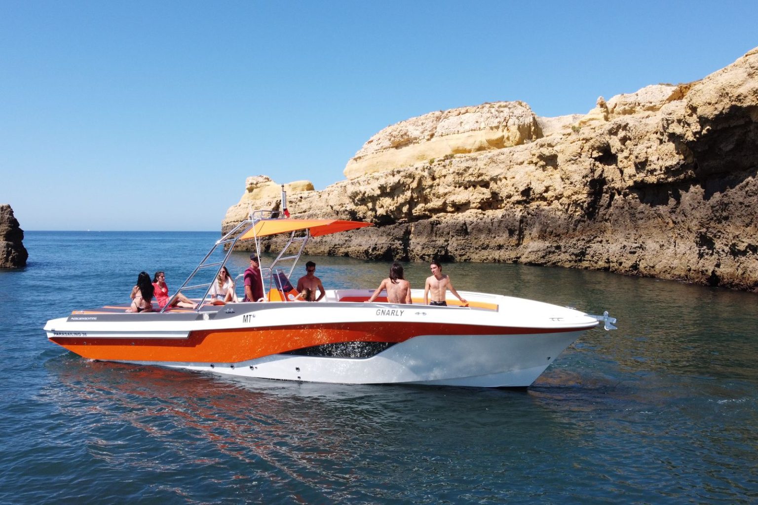Private speedboat with guests beside the cliffs near Benagil