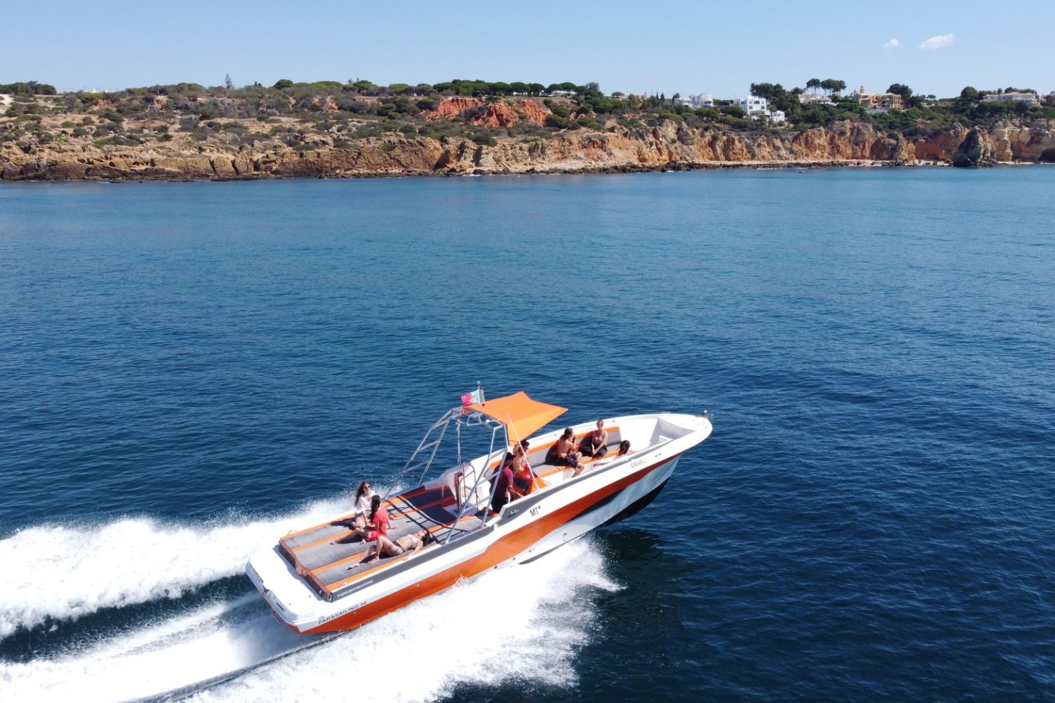 Private speedboat at speed along the Algarve cliffs
