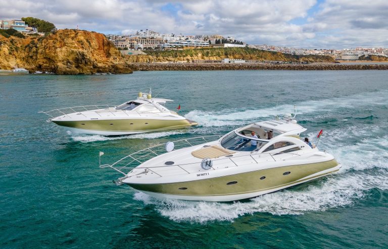 Two Sunseeker Portofino 53 yachts cruising past the cliffs outside Albufeira Marina