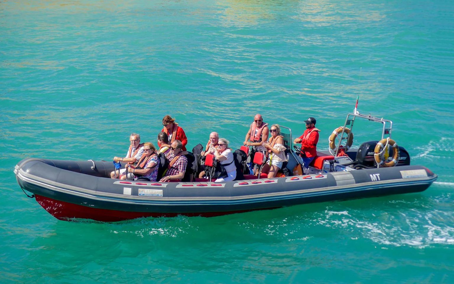 Semirrígido de grupo pequeno com skipper e convidados de colete perto de Albufeira