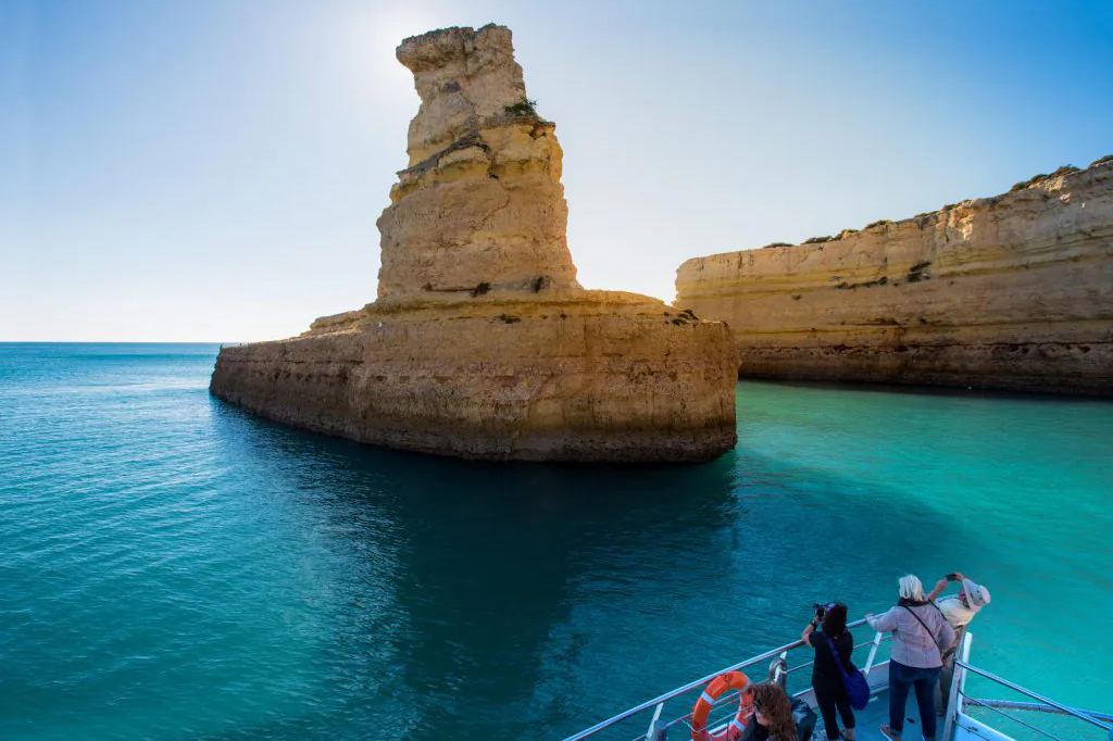 Boat beside sea caves and cliffs