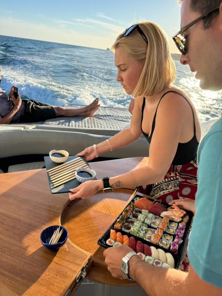 Guests sharing a sushi platter on a yacht