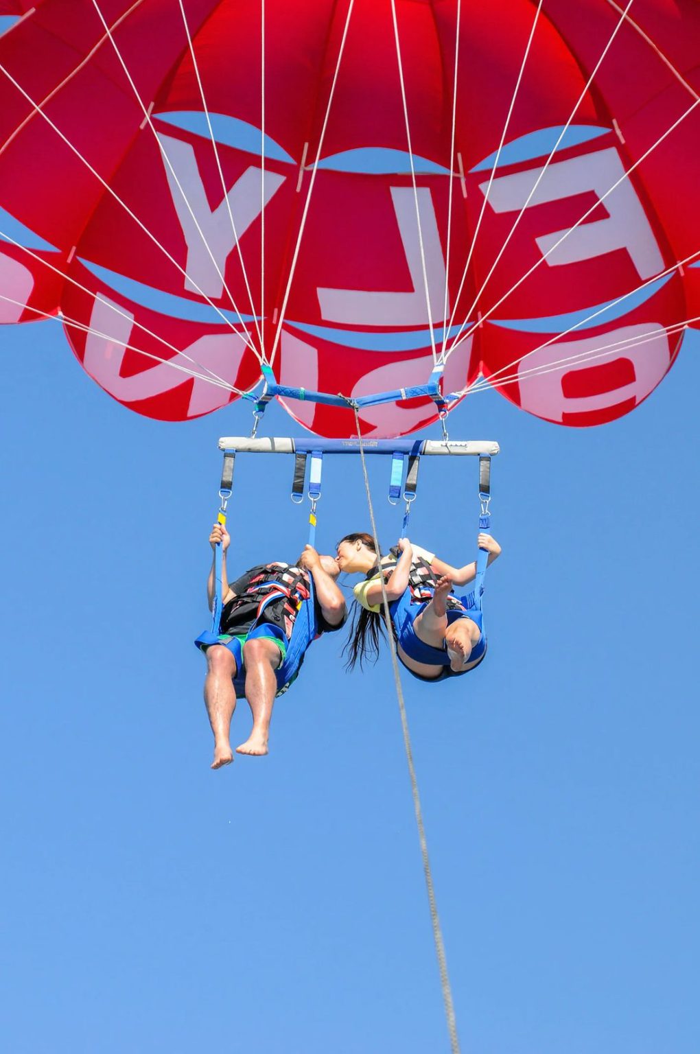 Casal a voar de parasailing sobre o mar em Albufeira