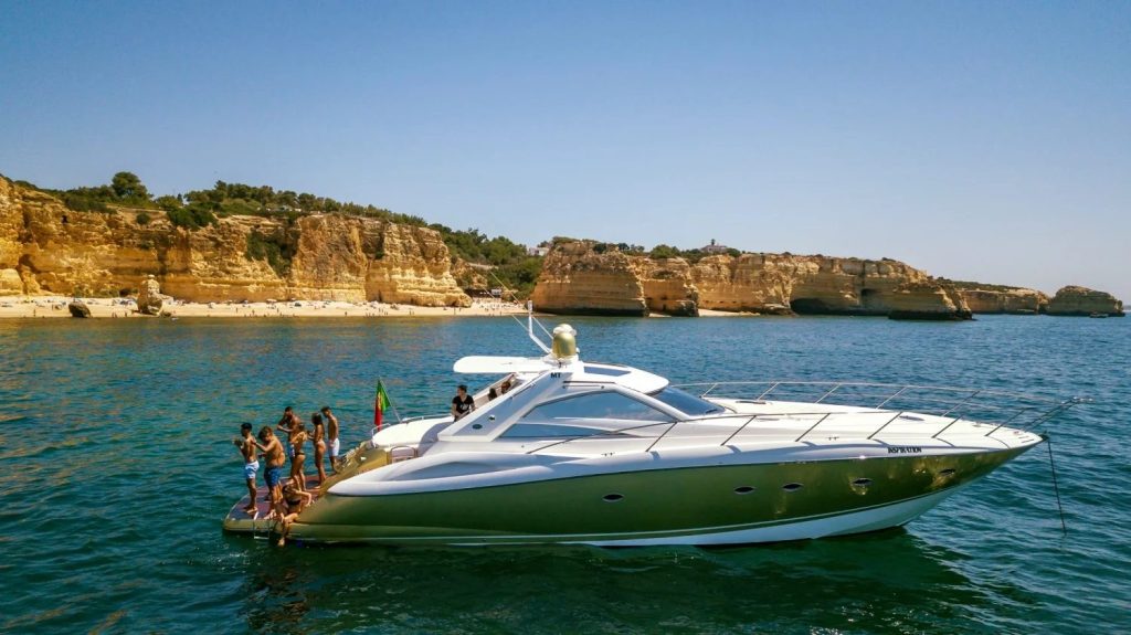 Convidados a saltar da plataforma de banho de um iate privado junto a uma praia dourada do Algarve